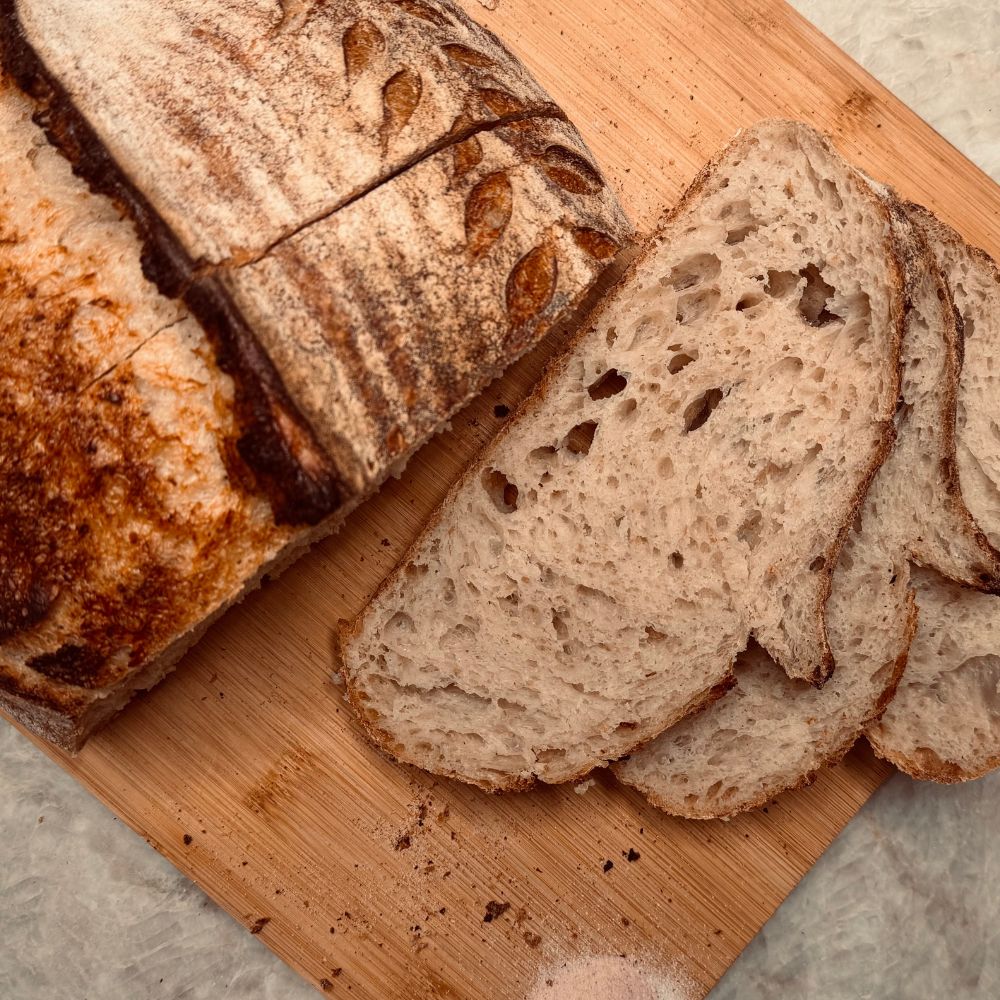 Loaf of bread with slices on a wooden cutting board