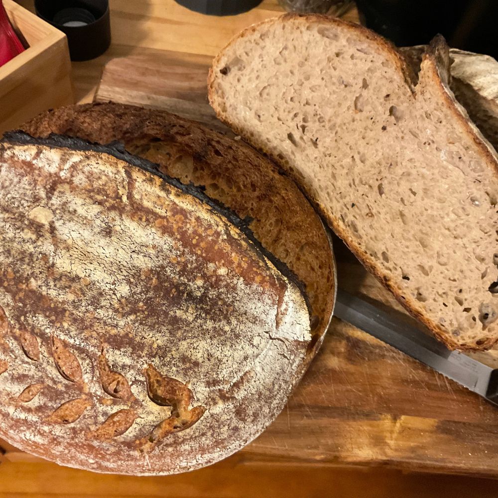 Loaves of bread on a wooden cutting board with a knife