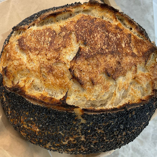 Loaf of bread with a dark crust on a paper background